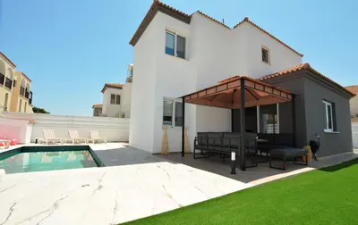 a backyard with a pool and a house at La Bella Nissi Villa in Ayia Napa