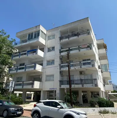 a white building with cars parked in front of it at Sunny 2 bedroom flat in Engomi in Engomi