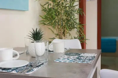 a table with plates and utensils on top of it at Piale Palms Makenzie Beach Front Apartment, Larnaca in Larnaka