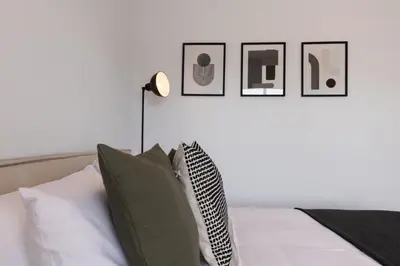 a bedroom with a bed with four pictures on the wall at Phaedrus Living Limassol Pyrgos Seaside Flat in Limassol