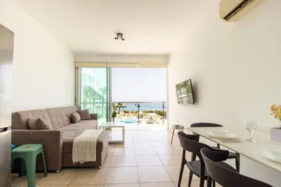 a living room with a couch and a table at Prime Protaras Seafront Apt in Protaras