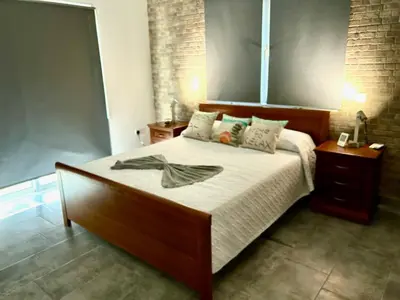 a bedroom with a large bed with a wooden headboard at Nissi Golden Sands Apartment D01 in Ayia Napa