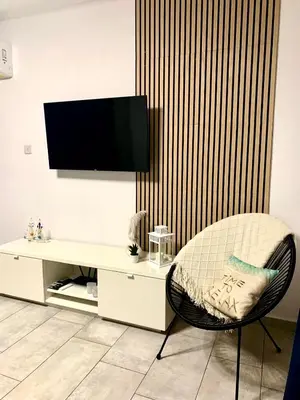 a living room with a chair and a white desk at Nissi Golden Sands Apartment D01 in Ayia Napa
