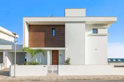 a white house with a wooden facade at Serenity Waves Villa 1 in Sophtadhes
