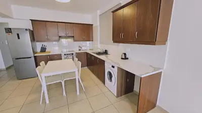 a kitchen with a white table and a white refrigerator at STAY Skyline Nest in Larnaka