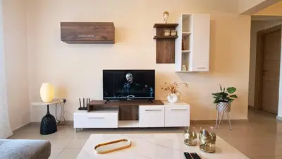 a living room with a tv on a white cabinet at NISSI BEACH Apt 2 RESORT AND SEA VIEW FREE WIFI in Ayia Napa