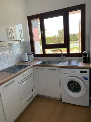 a kitchen with a sink and a washing machine at Modern 1 bedroom sea view beach apartment in Limassol