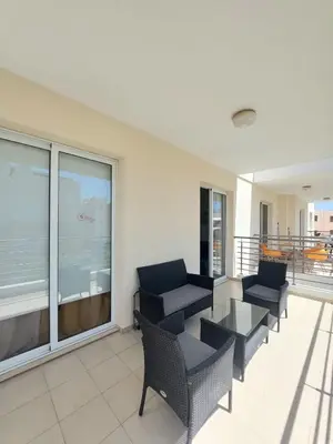 a living room with chairs and a table on a balcony at Mythical Sands - Aura in Paralimni