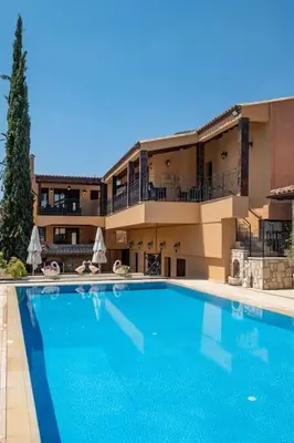 a large blue swimming pool in front of a building at Traditional House Agia Varvara Village in Ayvaryara