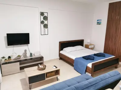 a bedroom with a bed and a blue couch at Must Stay - Finikoudes Studio in Larnaka