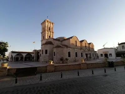 an old building with a clock tower on a street at Must Stay - Finikoudes Studio in Larnaka