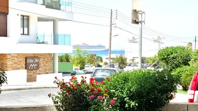 a car parked on the side of a street with flowers at Stylish Studio - 2 Minutes from Kastella Beach in Larnaka