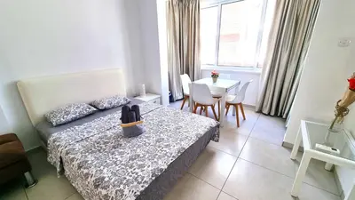 a bedroom with a bed and a table with chairs at Stylish Studio - 2 Minutes from Kastella Beach in Larnaka