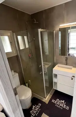 a bathroom with a shower and a toilet and a sink at A Detached Floor in Parekklisha