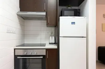 a kitchen with a white refrigerator and a stove at Old town studio in Limassol
