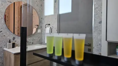 a row of glasses filled with yellow liquid in a bathroom at STAY Lima Soul Apartment in Limassol