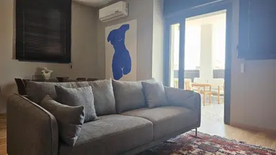 a living room with a couch and a painting of a woman at STAY Lima Soul Apartment in Limassol