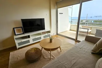 a living room with a couch and a tv and a table at Molos Beachfront City-Centre in Limassol
