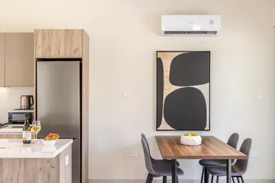 a kitchen and dining room with a wooden table and chairs at Protaras Mythical Seas in Protaras