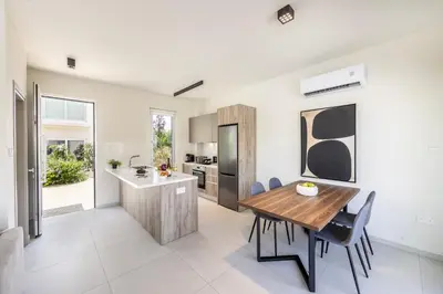 a kitchen and dining room with a wooden table and chairs at Protaras Mythical Seas in Protaras