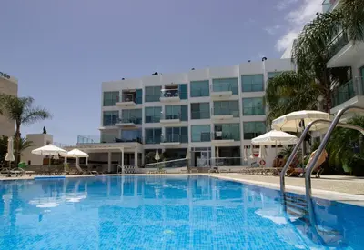 a large swimming pool in front of a hotel at Seafront Stylish Apt, Protaras in Protaras