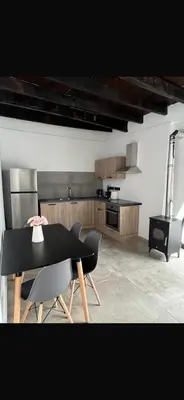 a dining room with a black table and chairs at Calavato Cottage in Kalavasos