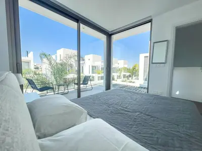 a bedroom with a bed and a large window at Azure Breeze Villa - Roof Garden & Sea Views in Protaras