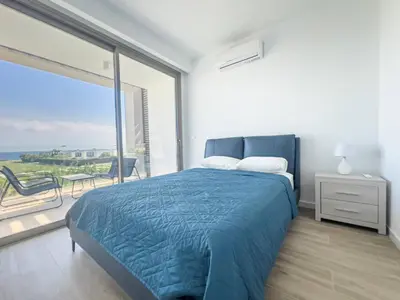 a bedroom with a blue bed and a large window at Azure Breeze Villa - Roof Garden & Sea Views in Protaras