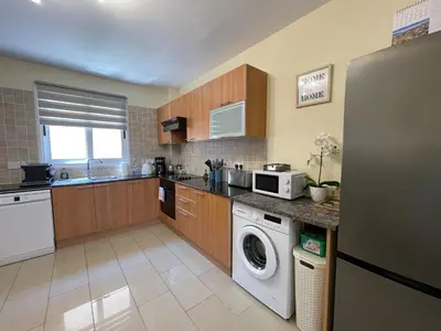 a kitchen with a washer and dryer in it at Nissi Beach beautiful apartment in Ayia Napa
