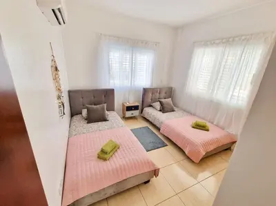 two beds sitting in a room with windows at Villa Malama in Paralimni