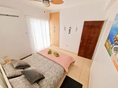 a bedroom with a bed with two green shoes on it at Villa Malama in Paralimni