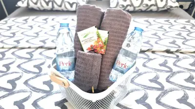 a basket with two bottles of water on a bed at Beachside Comfort - 2Br Apt,5 Min to the Beach in Larnaka