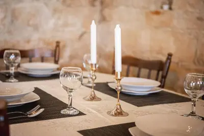 a table with candles and plates and glasses on it at Villa To Palati with Private Pool Anogyra in Anoyira