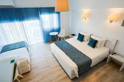 a bedroom with a bed and a table in it at Mikes Kanarium City Hotel in Larnaka