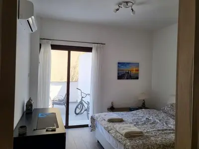 a bedroom with a bed and a desk and a window at Limassol mountain and sea views in Limassol