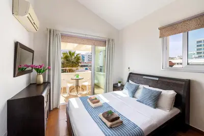 a bedroom with a large bed and a balcony at Villa Nora in Protaras