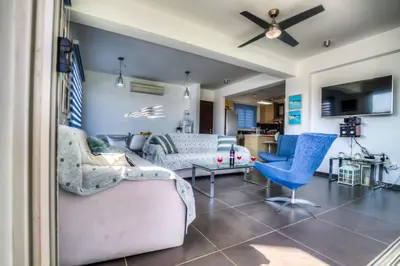 a living room with a couch and blue chairs at Beachfront Trident in Protaras