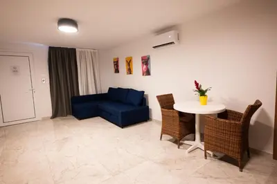 a living room with a blue couch and a table at Luca Apts Napa in Ayia Napa