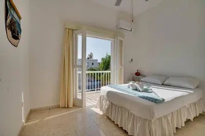 a bedroom with a large bed and a balcony at Ammos Villa 20 Side Seaview in Larnaka
