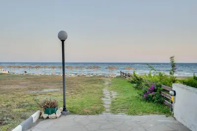 a street light next to a beach with umbrellas at Ammos Villa 20 Side Seaview in Larnaka