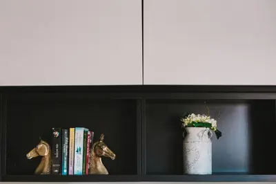 a book shelf with a vase and books on it at Neapolis Residence Spacious Quiet Near beach in Limassol