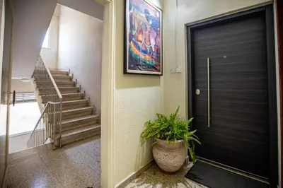 a hallway with a black door and a potted plant at Neapolis Residence Spacious Quiet Near beach in Limassol