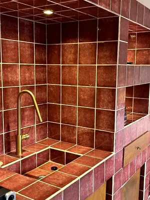 a kitchen with a sink and a copper tiled wall at Stin Avli tou Pavlou Guest House in Omodos