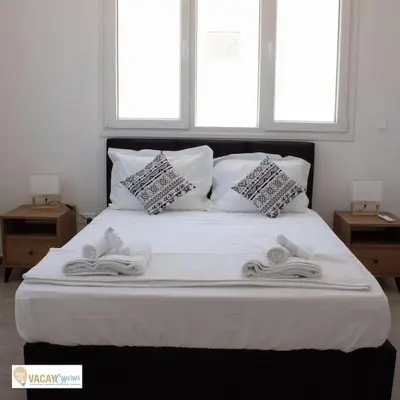 a white bed with two pillows and towels on it at Villa Orash in Larnaka