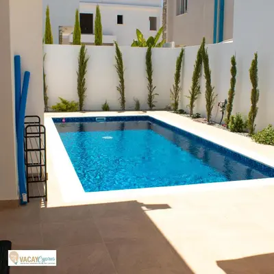 a swimming pool in a backyard with a fence and trees at Villa Orash in Larnaka