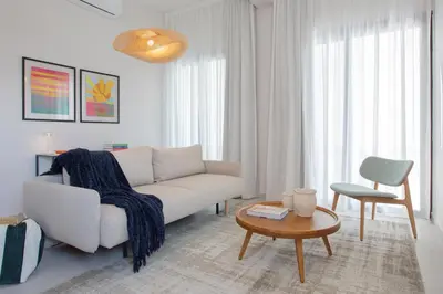 a living room with a white couch and a table at LIV & CO Suites & Villas in Voroklini