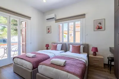 two beds in a room with windows at Aura 2-Bedroom Apartment in Larnaca in Larnaka