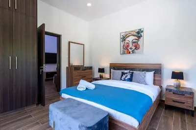 a bedroom with a large bed with a blue blanket at Aura 2-Bedroom Apartment in Larnaca in Larnaka