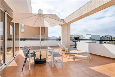 a patio with a table and chairs and an umbrella at Top Floor Apartment City Center in Larnaka