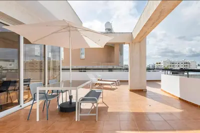 a patio with a table and chairs and an umbrella at Top Floor Apartment City Center in Larnaka